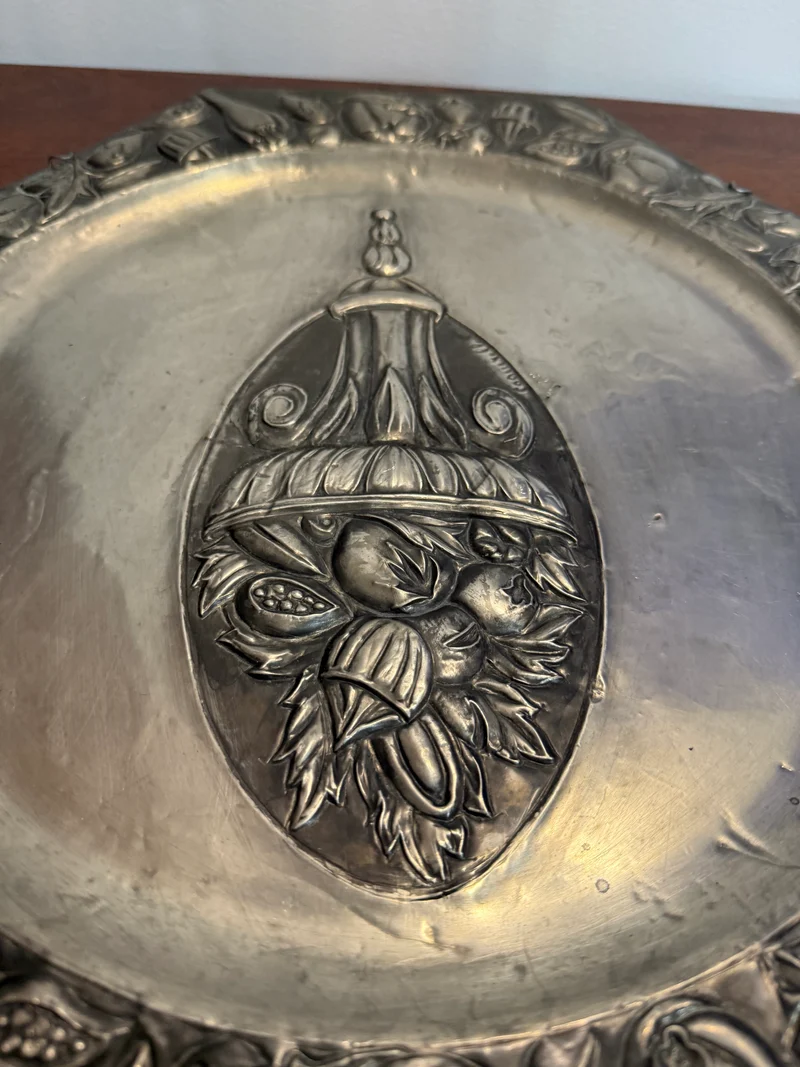 Grande assiette murale en métal repoussé signée Coquerelle – décor corbeille de fruits